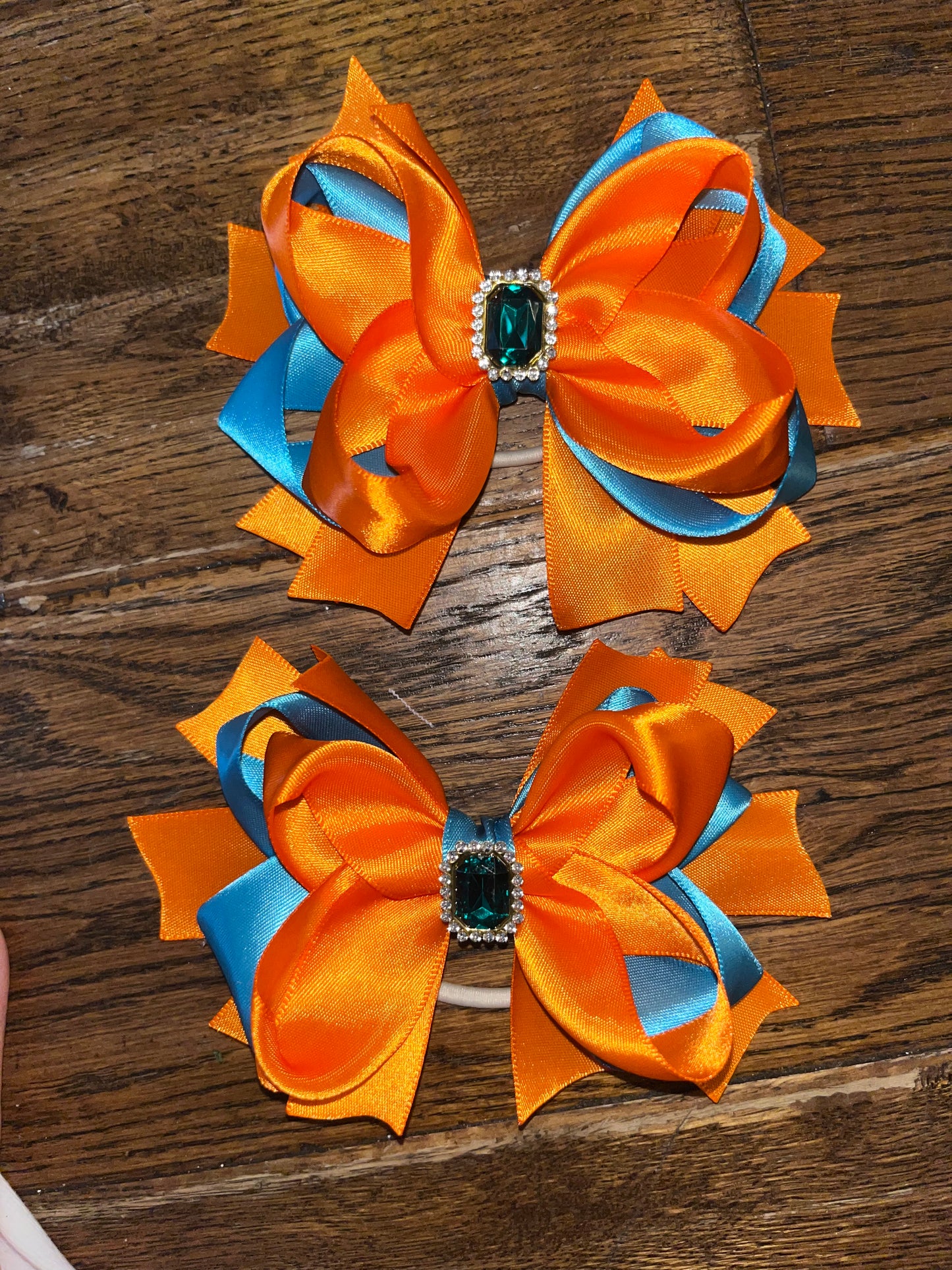 pair of teal and orange bows with embellishment