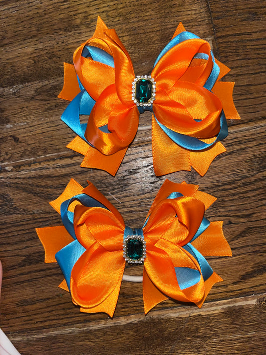 pair of teal and orange bows with embellishment